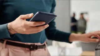 Women holding her phone in front of a printer
