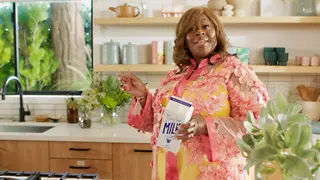 Retta holding a paper carton of milk